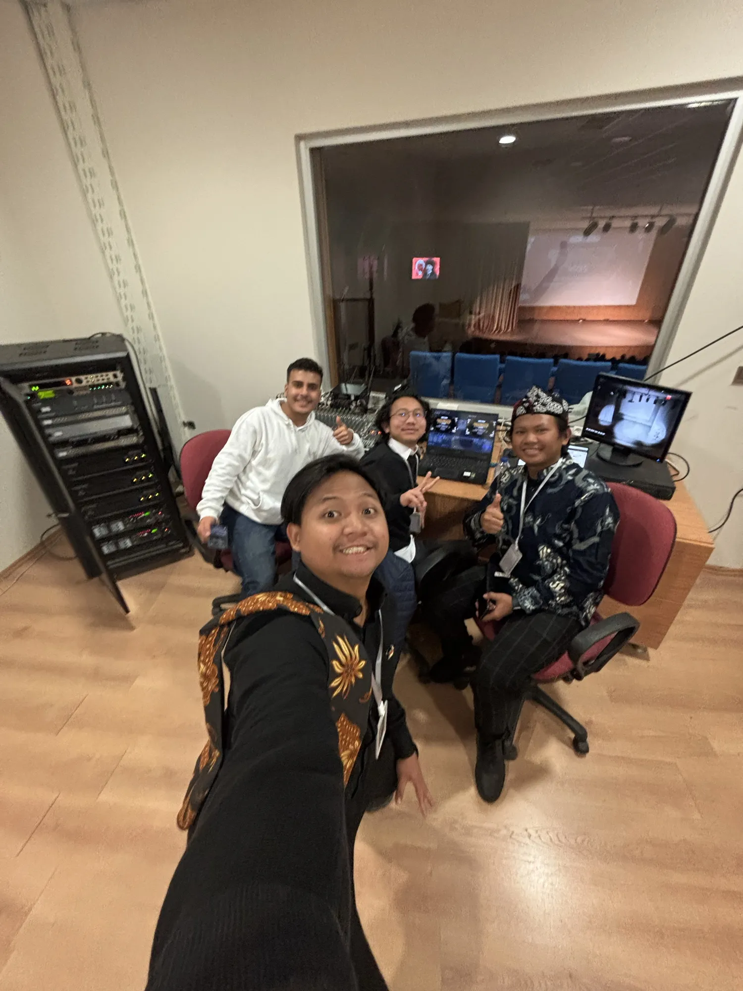 A selfie with friends in a room full of monitors and editing gear